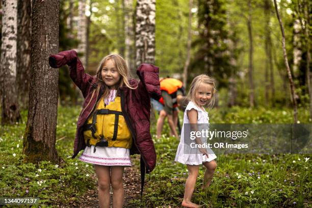 girl with sister wearing oversized jacket and life jackt in forest - loose ストックフォトと画像