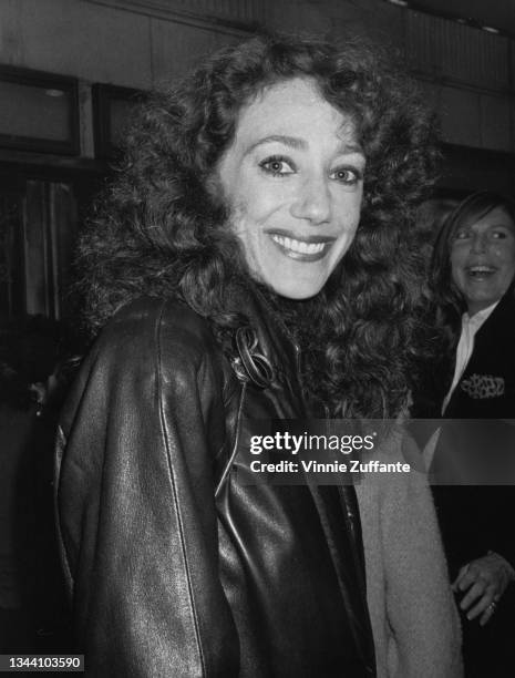 American actress and fashion model Marisa Berenson wearing a black leather jacket turns to smile during an unspecified event, location unspecified,...