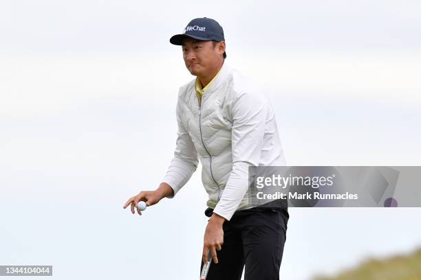Haotong Li of China acknowledges the crowd following his round on the 18th green during Day One of The Alfred Dunhill Links Championship at...