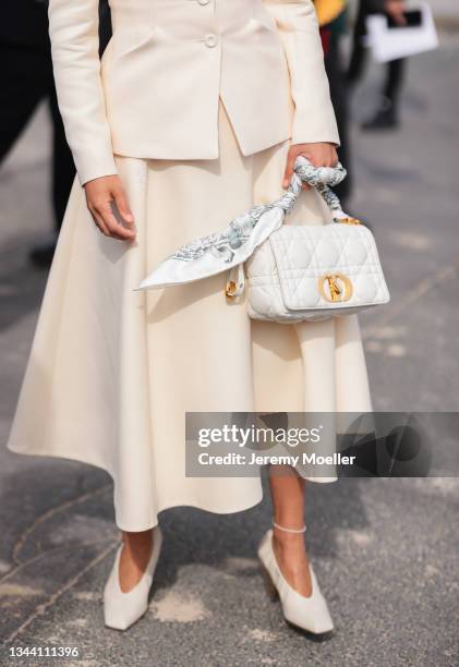 Aimee Song wearing a white blazer and skirt, a white dior bag and white heels on September 28, 2021 in Paris, France.
