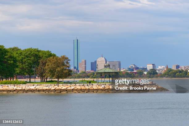 boston skyline viewed across water using a 135mm lens - south boston massachusetts photos et images de collection