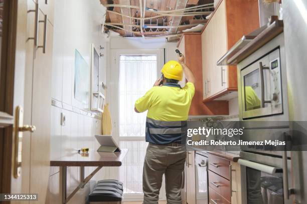 plumber assessing damage from a broken pipe. water leakage - home inspection photos et images de collection