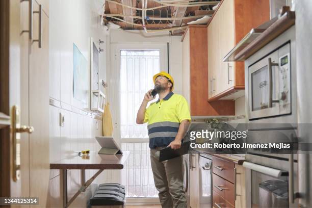 surveyor assessing the damage. collapse of the roof of a house - seguro del hogar fotografías e imágenes de stock