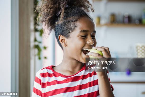 linda chica comiendo una manzana - apple fruit fotografías e imágenes de stock