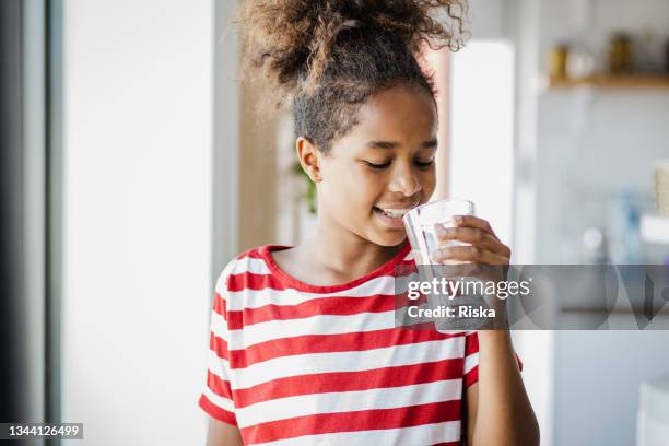 süßes mädchen, das wasser trinkt - african girl drinking water stock-fotos und bilder