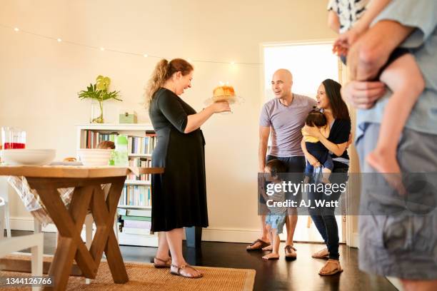 woman surprising her friends with birthday party celebration - holding birthday cake stock pictures, royalty-free photos & images