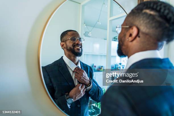 young businessman motivates himself in front of a mirror - spiegel stockfoto's en -beelden
