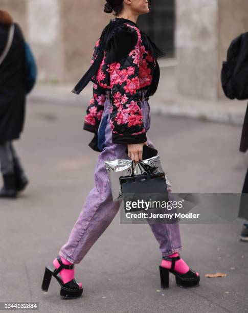 Fashion week guest wearing black and pink kimono top, pink washed denim jeans, neon pink socks and black chunky heels on September 29, 2021 in Paris,...