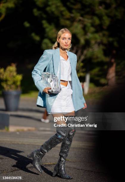 Leonie Hanne seen wearing silver Bottega Veneta bag, silver glitter boots, blue jacket, white skirt and button up shirt outside Coperni during Paris...