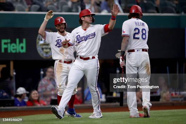 Peters of the Texas Rangers celebrates with Nick Solak of the Texas Rangers and Jonah Heim of the Texas Rangers after scoring on a two-run double hit...