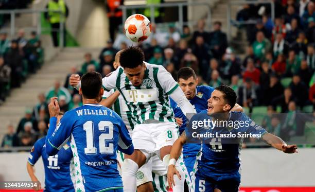 Ryan Mmaee of Ferencvarosi TC heads the ball next to Marc Bartra of Real Betis during the UEFA Europa League group G match between Ferencvarosi TC...