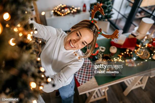 junge frau, die das wohnzimmer schmückt - dekorieren stock-fotos und bilder