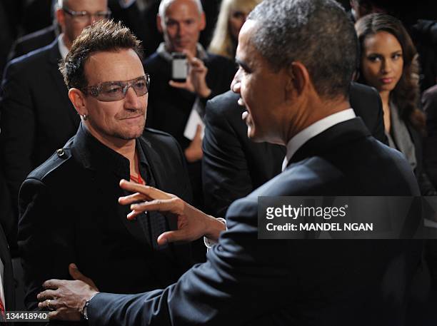 President Barack Obama chats with muscian Bono as singer Alcia Keys looks on after speaking at a World AIDS Day event December 1, 2011 at George...