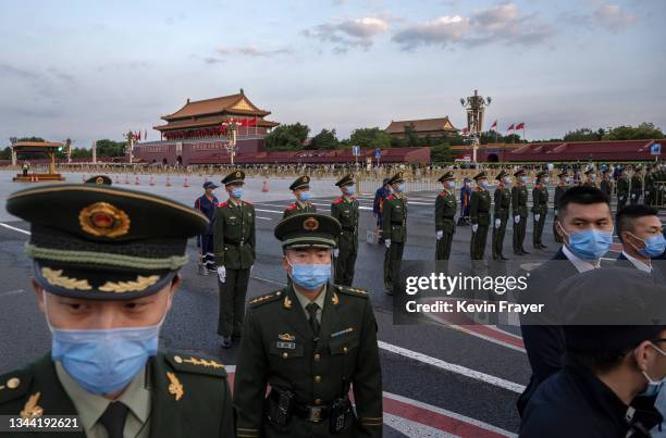 Police officers and security block the way as they perform crowd control after an official flag raising ceremony to mark National Day next to...