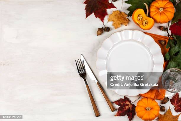 autumn table setting with plate, pumpkins and leaves. happy thanksgiving day. - thanksgiving day stock-fotos und bilder