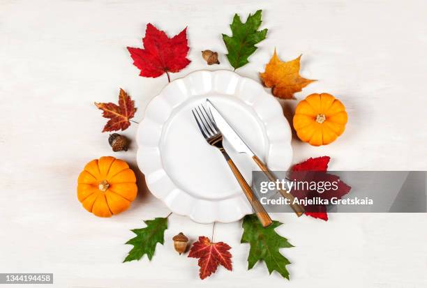 autumn table setting with plate, pumpkins and leaves. happy thanksgiving day. - squash seeds stock-fotos und bilder