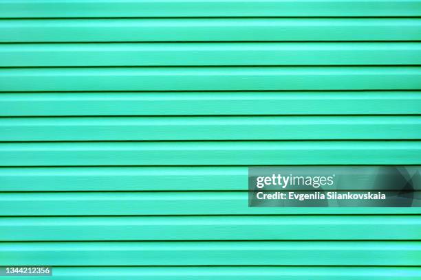 bright mint color painted building wall background. - garagentor stock-fotos und bilder