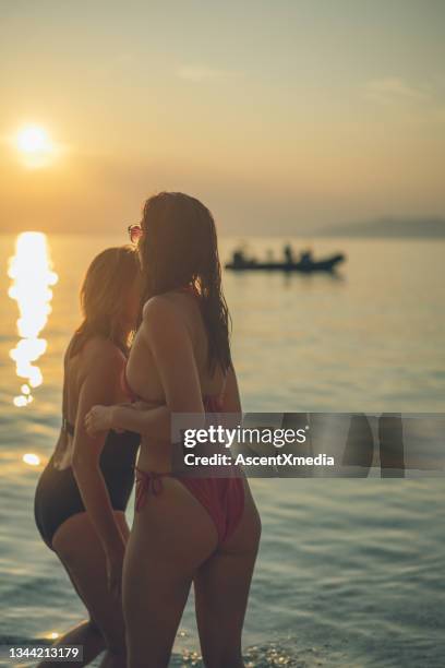 mother and daughter walk down beach at sunrise - mother and child in water at beach stock pictures, royalty-free photos & images