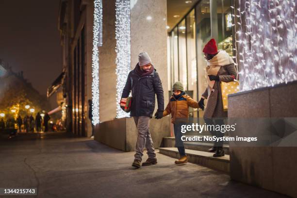 famiglia nera nello shopping natalizio, lasciando il centro commerciale - retail economy ahead of christmas holiday season foto e immagini stock