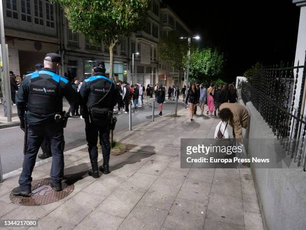 Police officers monitor groups of young people on the streets of Santiago de Compostela, on October 1 in Santiago de Compostela, Galicia, Spain. The...