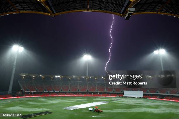 Lightning is seen during a rain delay on day two of the Women's International Test match between Australia and India at Metricon Stadium on October...