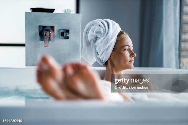 young woman enjoying in her bubble bath. - woman in bathroom stockfoto's en -beelden