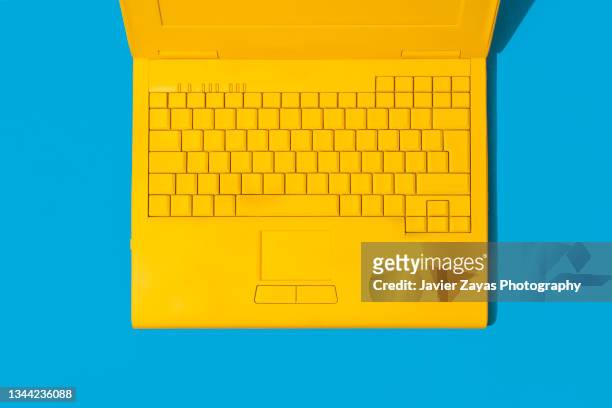 yellow laptop on blue background - office work flat lay foto e immagini stock