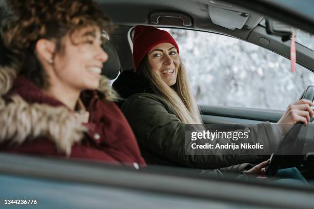 two female friends enjoying their weekend getaway - winter friends stock pictures, royalty-free photos & images