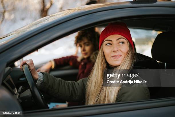 schöne frau, die einen wochenend-roadtrip mit ihrer freundin genießt. - auto winter stock-fotos und bilder