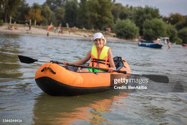 teenager having fun kayaking on a lake - teens canoeing stock pictures, royalty-free photos & images