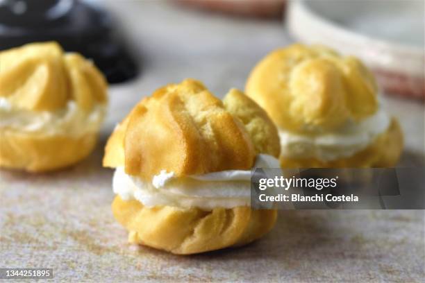 profiteroles or cream puffs - choux pastry stock pictures, royalty-free photos & images