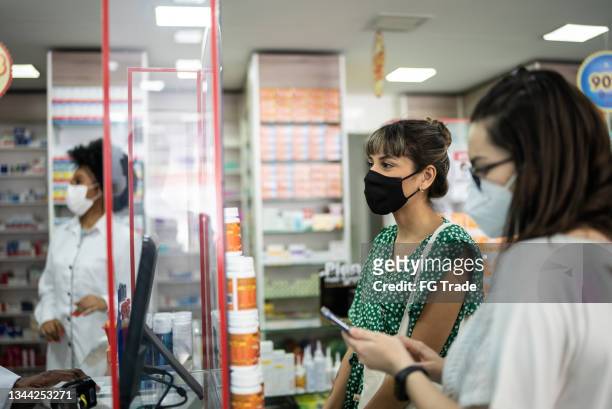 young women asking for help at the pharmacy - wearing a face mask - pharmacy mask stock pictures, royalty-free photos & images
