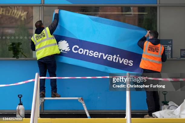 Workers erect Conservative Party branding on the windows of Manchester Central ahead of the Conservative party conference on October 01, 2021 in...