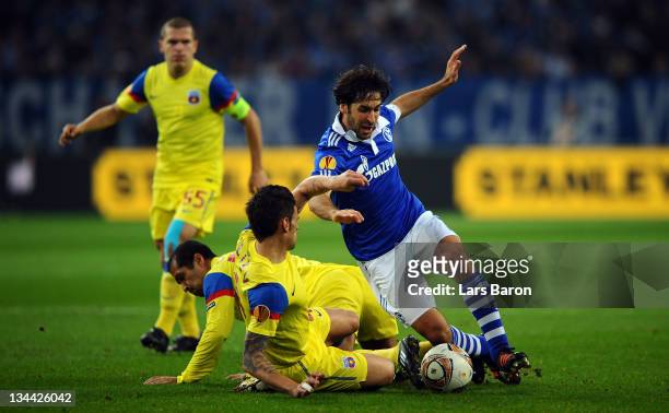Raul Gonzalez of Schalke is challenged by Valentin Iliev and Geraldo Alves of Steaua during the UEFA Europa League group J match between FC Schalke...