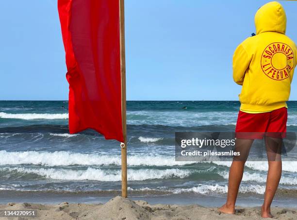 closeup of spanish lifeguard or socorrista stands guard on windswept majorcan beach, balearic islands, spain - socorrista 個照片及圖片檔