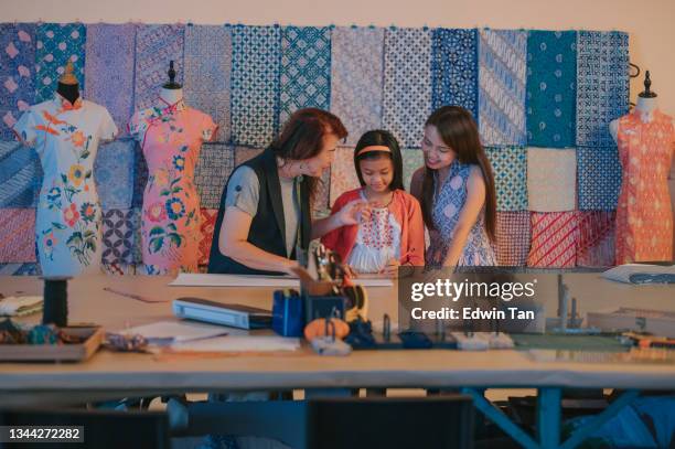 multi generation asian chinese grandmother teaching her granddaughter drawing clothing design at her studio - design studio stock pictures, royalty-free photos & images