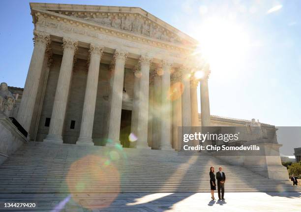 Supreme Court Associate Justice Amy Coney Barrett and Chief Justice John Roberts pause for photographs on the plaza in front of the west side of the...