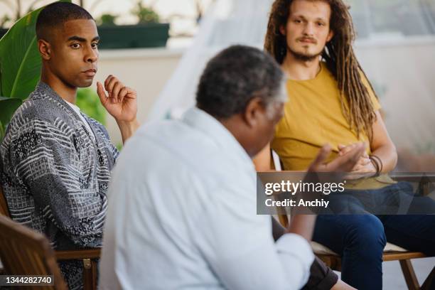 senior man talks during support group meeting - vulnerability stock pictures, royalty-free photos & images