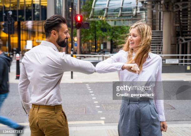 elbow bump greeting - touching elbows stock pictures, royalty-free photos & images