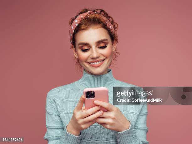 close-up portrait of a young pretty girl using smart phone - girl smiling stockfoto's en -beelden