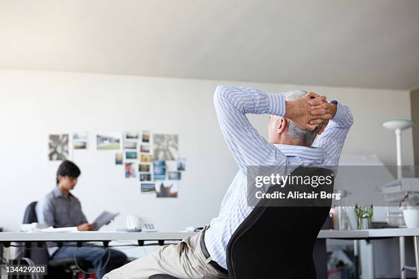 businessman relaxing at his desk - intermission 個照片及圖片檔