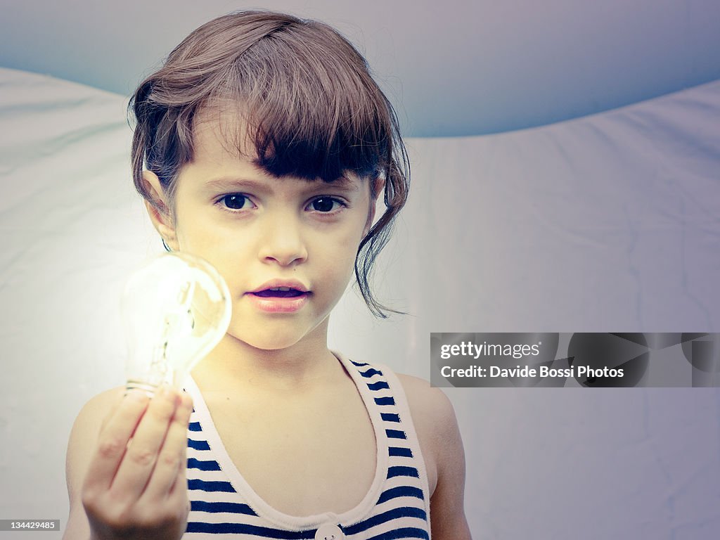 Baby girl holding light bulb