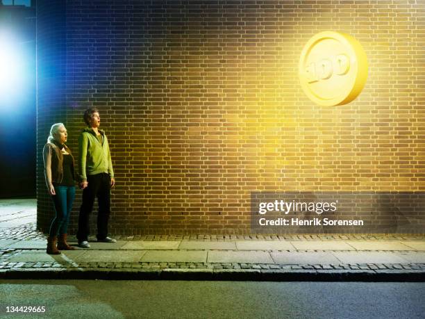 young couple in the street, looking up at coin - awards night fotografías e imágenes de stock