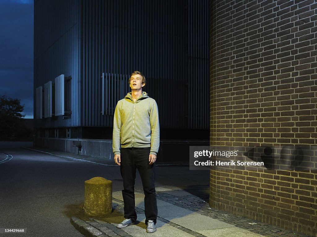 Young man in urban environment looking up
