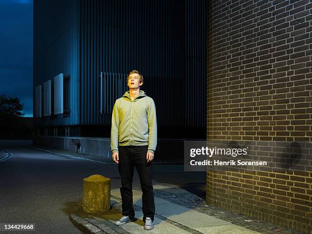 young man in urban environment looking up - surprise foto e immagini stock