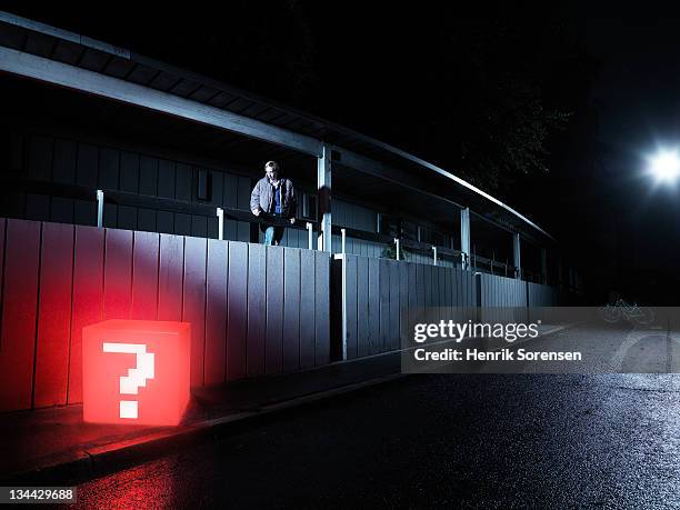 young man in urban environment finding red box - treasure hunt stock pictures, royalty-free photos & images