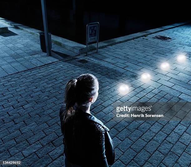 young woman in front of glowing balls - woman capturing city night foto e immagini stock