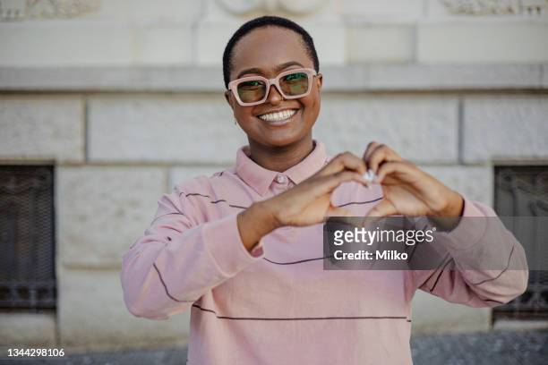 african-american woman forming a heart shape with her fingers - pleased face laptop stock pictures, royalty-free photos & images