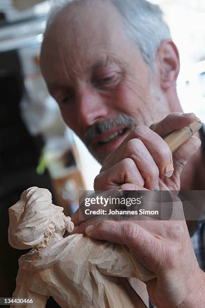 Woodcarver Herbert Haseidl carves a figurine in the shape of a oriental dressed Holy King for a Christmas crèche at his workshop on December 1, 2011...