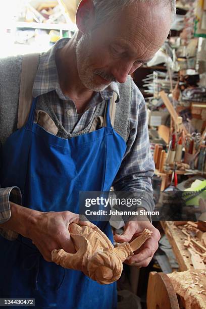 Woodcarver Herbert Haseidl carves a figurine in the shape of a oriental dressed Holy King for a Christmas crèche at his workshop on December 1, 2011...